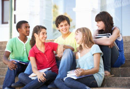 estudiantes-3 Teenage Friends Sitting On College Steps Outside