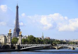 Paris scene with River Seine, Pont Alexandre III and skyline with Eiffel Tower in the distance.